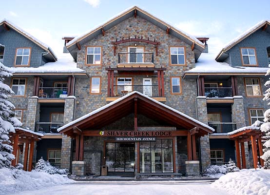 A photo taken in the Kananaskis valley looking up at the Three Sisters mountains in fall.