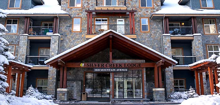 A photo taken in the Kananaskis valley looking up at the Three Sisters mountains in fall.