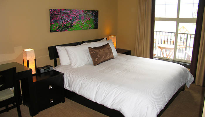 Queen bed and bedroom in the One Bedroom Suite at Silver Creek Lodge.