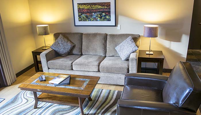 Comfy couch and armchair in the roomy living room in the Two Bedroom Suite.